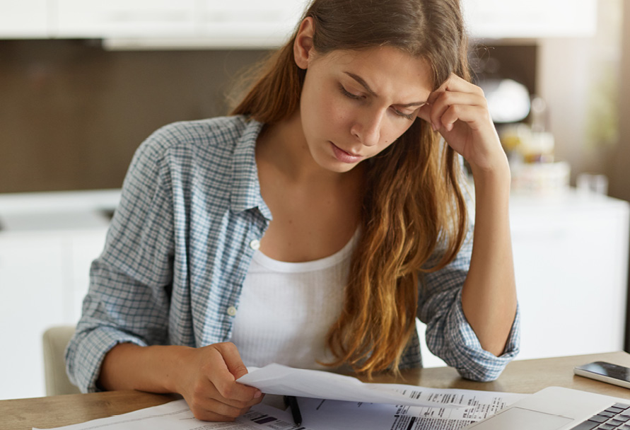 Woman sitting at a table and looking at papers