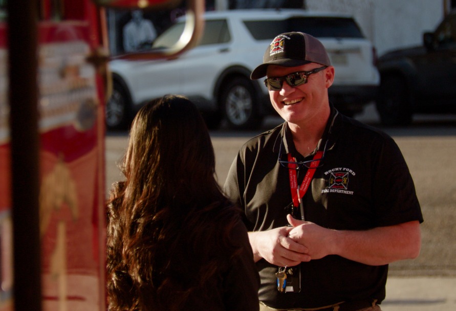 A firefighter in Colorado speaking to a woman with her back to the camera
