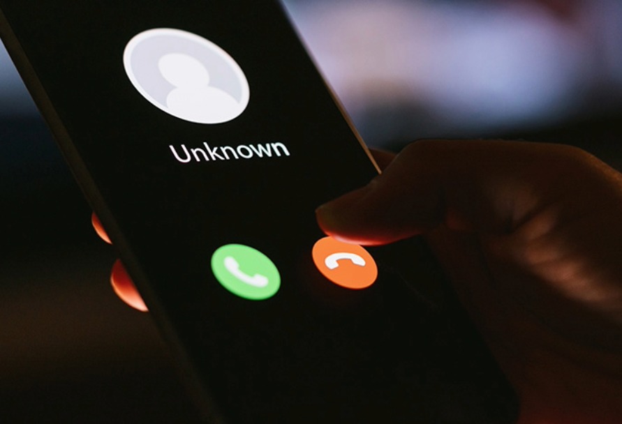 Close up of a hand holding a smartphone with an incoming call coming from an unknown caller
