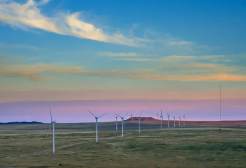Busch Ranch wind project turbines in Colorado against a colorful sunset