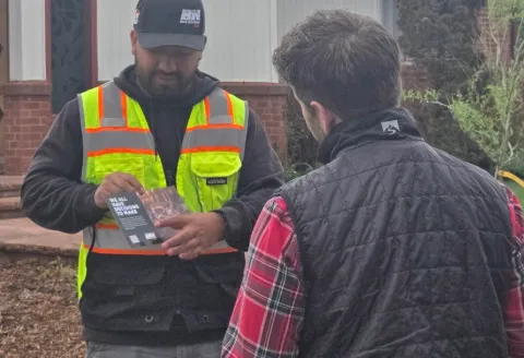 Gas tech holding a brochure and talking to a customer